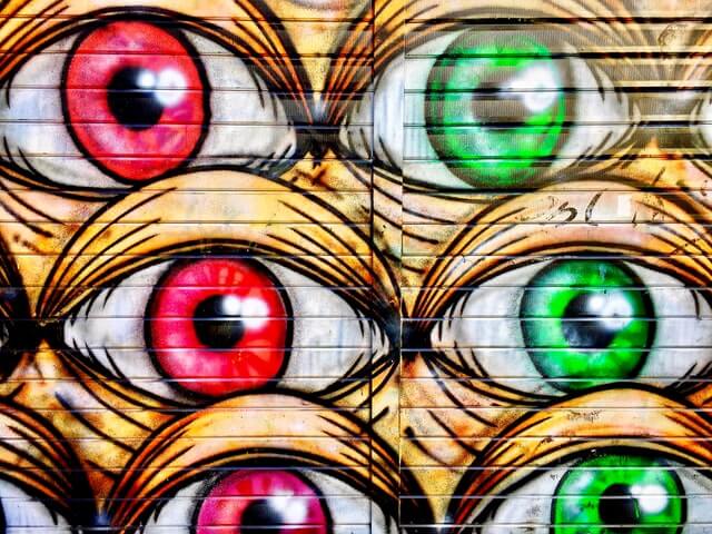 street art de trois yeux rouges et trois yeux verts