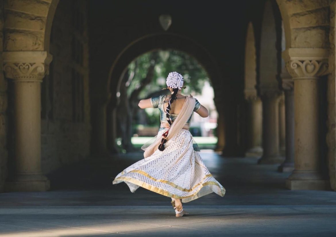 Une indienne en sari blanc de dos qui court vers un tunnel